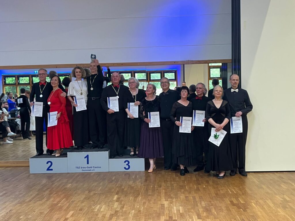 Hartmut und Monika stehen mit allen sechs Paaren des Finals auf dem Foto. Sie halten die Siegerurkunde in der Hand und stehen auf dem 3. Platz.