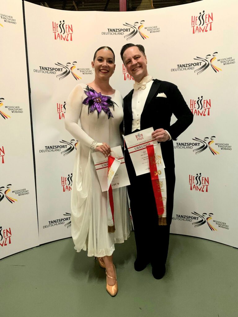 Pia und Neil halten auf dem Foto den Wimpel und die Urkunde in die Kamera